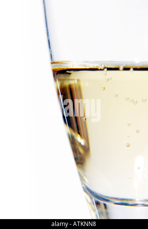 Close up d'un demi-verre de liquide clair jaunâtre fizzy Banque D'Images
