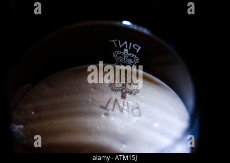 Le symbole pinte jette une ombre sur les bières de la mousse. Banque D'Images