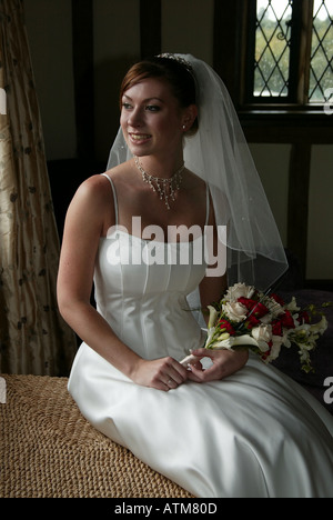 Bride pour photographie avant la cérémonie du mariage et à la fenêtre de Banque D'Images