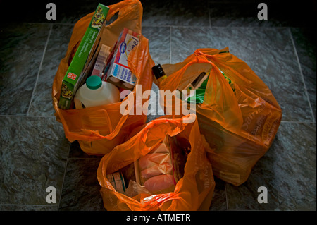 Sacs en plastique orange rempli de shopping, on estime que 1,5 milliards ont été utilisés depuis les sacs UK a commencé à éliminer progressivement les Banque D'Images