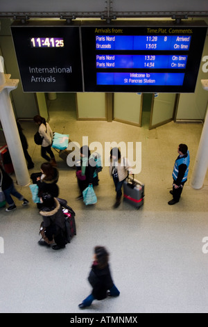 Navetteurs quittant la plate-forme eurostar sous le panneau indicateur des arrivées internationales, gare de St Pancras Londres, Royaume-Uni Banque D'Images