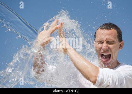 Man getting éclaboussé avec de l'eau contre un ciel bleu en Inde Banque D'Images