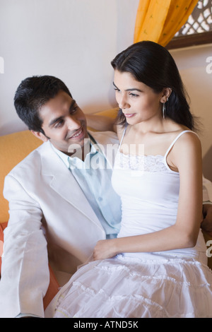 Jeune femme assise sur les genoux d'un jeune homme Banque D'Images