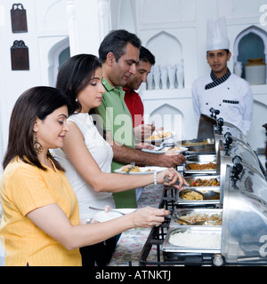 Portrait of mid adult couples ayant deux aliments dans une partie Banque D'Images