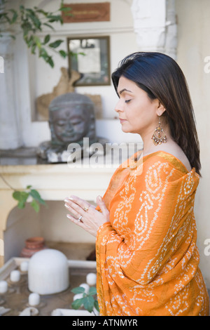 Mid adult woman priant devant le Seigneur Shiva Banque D'Images