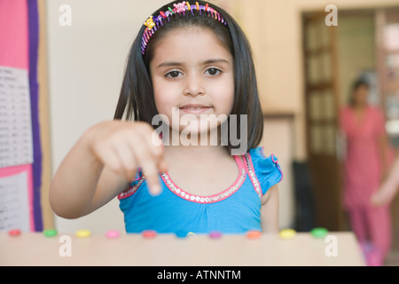 Portrait d'une lycéenne en direction de bonbons et smiling Banque D'Images