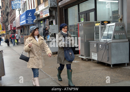 Les femmes à la mode de marche passé grungy alimentation restaurant vendeurs sur l'évolution de Bowery à NEW YORK Banque D'Images