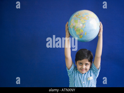 Portrait d'un écolier holding a globe Banque D'Images