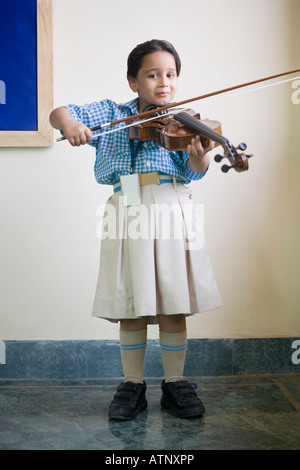 Portrait d'une écolière jouant un violon dans un cours de musique Banque D'Images