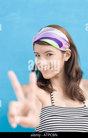 Portrait d'une jeune femme montrant un signe de paix Banque D'Images
