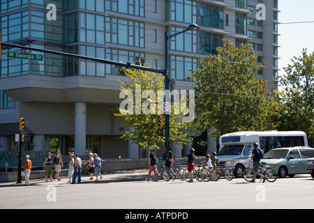 Les gens avec des vélos marche sur passage pour piétons à la jonction de la rue Vancouver Canada Banque D'Images