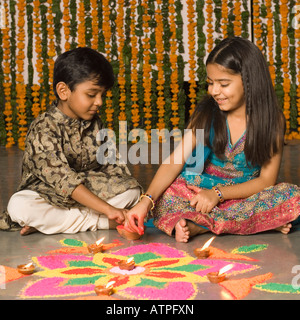 Garçon et sa sœur faire rangoli Banque D'Images