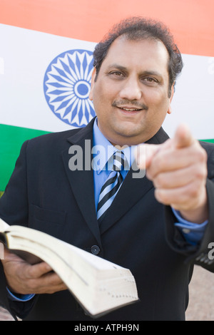 Portrait of a young man holding a book et orientée vers l'avant Banque D'Images