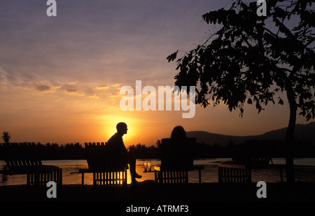 Un couple de Kampot pour le coucher du soleil sur les rives de la rivière Prek Kampong Banque D'Images