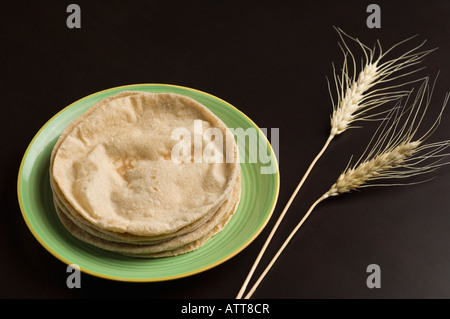 Close-up de chapattis dans une plaque avec des cosses de blé Banque D'Images