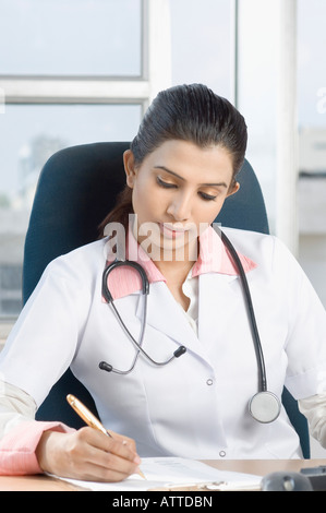 Femme médecin assis sur une chaise et tenant un stylo Banque D'Images
