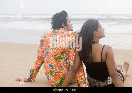 Vue arrière d'un jeune couple assis sur la plage Banque D'Images