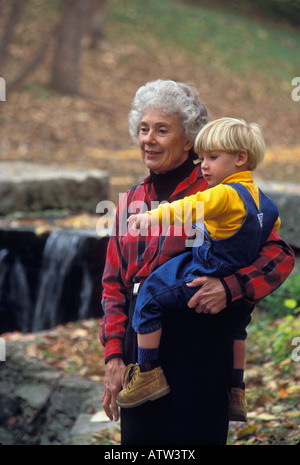 Vieille Femme tenant son petit-fils à l'extérieur à l'automne Banque D'Images