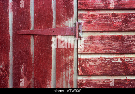 Détail de la porte et le mur de bois hut ou beach-hut ou jeter une fois coloré rouge écarlate mais maintenant résisté fortement Banque D'Images