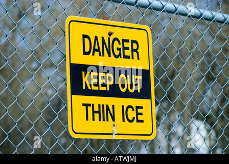 Panneau Danger Garder hors de la glace mince suspendu à une clôture de Banque D'Images