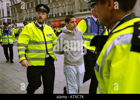Les agents de police à l'arrestation d'un jeune homme lors d'une manifestation dans le centre de Londres, Mayday 2003. Banque D'Images