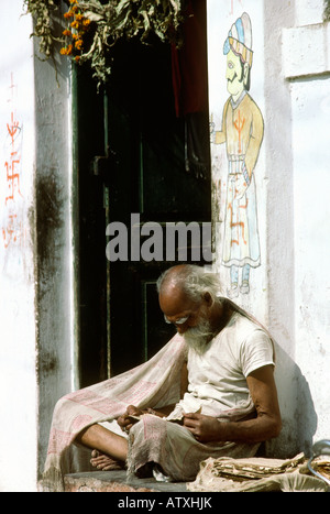 Inde Rajasthan Udaipur man reading newspaper assis dehors Maison décoration Banque D'Images