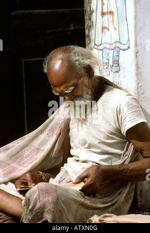 Inde Rajasthan Udaipur man reading newspaper assis dehors Maison décoration Banque D'Images