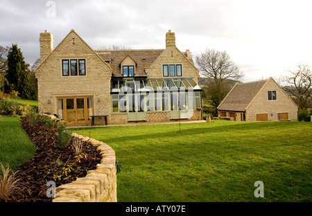 Nouvelle maison individuelle en pierre de Cotswold sur l'escarpement du Cotswold Woodmancote près de Cheltenham UK Banque D'Images