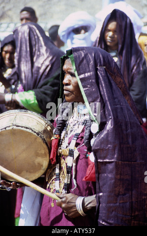 Sahara Tuareg femmes vêtues de robes indigo cirées au festival Sebiba jouant à ganga, en Algérie du sud Banque D'Images