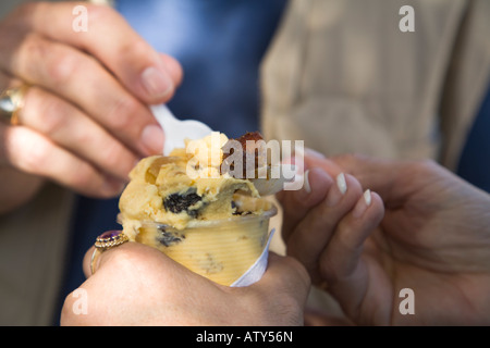 Mexique Dolores Hidalgo mains de l'homme et de la femme la consommation de crème glacée achetée auprès de vendeur de rue dans la région de plaza spécialité locale Banque D'Images