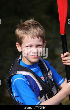 Portrait de jeune garçon tourisme aventure en famille Vacances en Croatie portant un gilet et pagaie pour kayak holding Banque D'Images