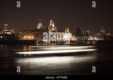 Liverpool skyline at night a vu de plus de la Mersey avec le mouvement du ferry en passant par Banque D'Images