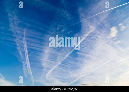 Grand angle horizontal d'un ciel bleu profond avec plusieurs formations du nuage de vapeur et de sentiers dans le cadre d'une journée d'été Banque D'Images