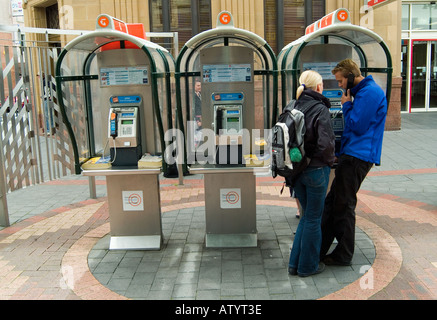 Couple utilisant des téléphones publics de style ancien Hobart Tasmanie Australie Banque D'Images