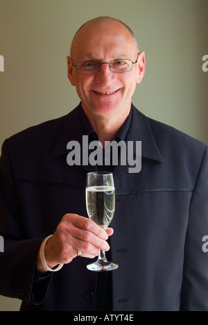 L'homme à la tête rasée costume noir avec coupe de champagne Banque D'Images