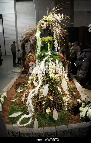 Affichage Floral créé à l'image d'une vieille cloche. Robe longue de brindilles plumes boas et orchidées feuilles Banque D'Images