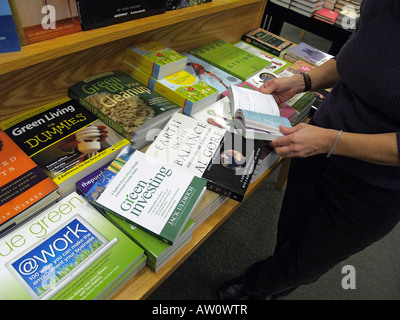 Femme feuilletant des sélections de livres sur la vie en vert à la librairie Barnes & Noble, New York, USA, © Katharine Andriotis Banque D'Images