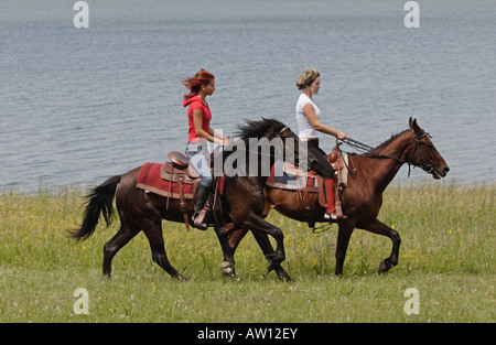 Deux jeunes filles allant sur les chevaux Banque D'Images