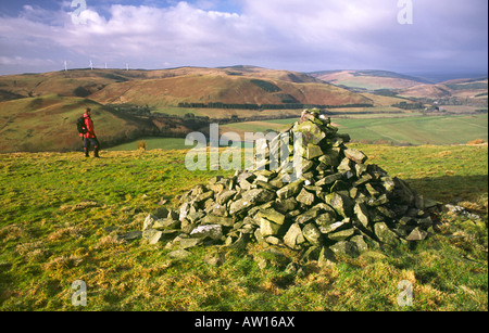 La randonnée d'hiver Ecosse Hill walker près de Langholm cairn sur Potholm Hill jusqu'à Eskdale Dumfriesshire Scotland UK Banque D'Images