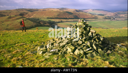 La randonnée d'hiver Ecosse Hill walker près de Langholm cairn sur Potholm Hill jusqu'à Eskdale Dumfriesshire Scotland UK Banque D'Images