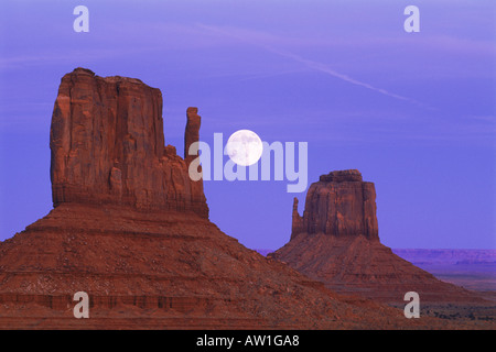 Lune situé entre les mitaines à Monument Valley Arizona Banque D'Images