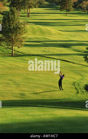Male golfer hitting fairway en faible lumière au coucher du soleil Ranch Golf Club à Kelowna, British Columbia Canada Banque D'Images