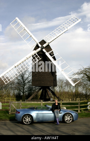 Une femme se trouve à côté de l'Aston Martin V8 Vantage Roadster à grands Gransden moulin dans le Cambridgeshire Banque D'Images