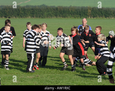 Les jeunes garçons à jouer au rugby avec coach formateur Banque D'Images