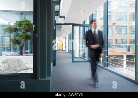 Homme marchant à travers un édifice bancaire Banque D'Images