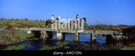 Deux chevaux et cavaliers traversant le pont au-dessus du clapet de Lank River sur la lande de Bodmin Cornwall Angleterre Banque D'Images