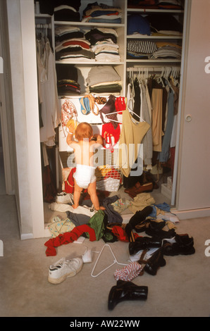 Bébé dans la chambre parents penderie Créer mess mixte de chaussures et vêtements Banque D'Images