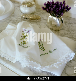 Petites serviettes en coton avec motif fleur brodée main sur surface en marbre Banque D'Images