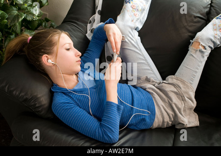 Jeune fille de l'adolescence avant avec lecteur mp3 et téléphone à l'intérieur Banque D'Images