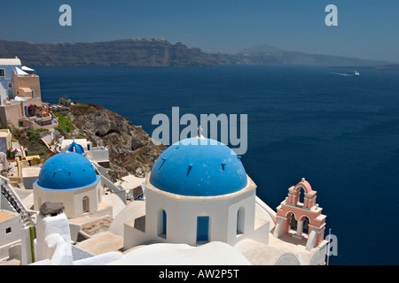 Église avec dôme bleu clocher rose surplombant la mer Méditerranée à Santorini Banque D'Images